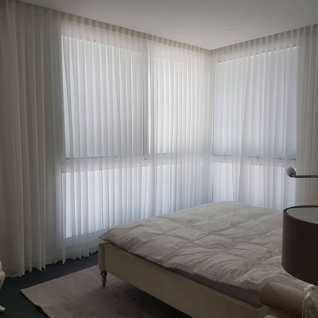 וילונות בד שקופים לבנים בפינת חדר שינה