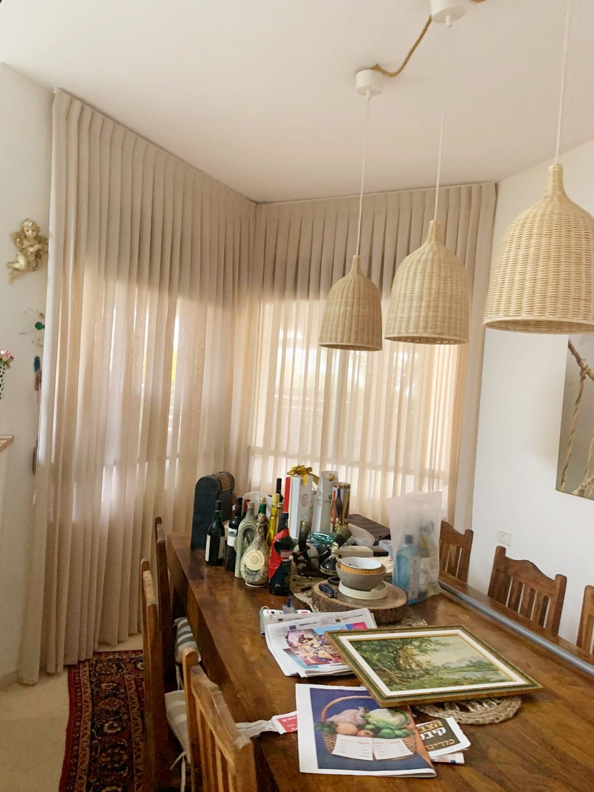 וילונות בד בגוון שמנת בפינת אוכל עם גופי תאורה